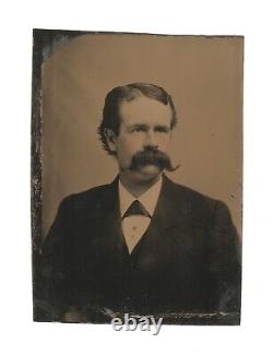 Ancienne photo de type Tintype avec un bel homme jeune au large moustache en guidon de vélo