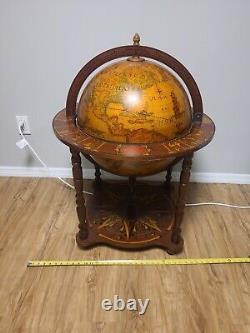 Traduisez ce titre en français : Globe terrestre en bois à l'aspect ancien, vintage et antique, avec bar caché sur roulettes, tel qu'illustré.