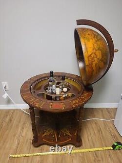 Traduisez ce titre en français : Globe terrestre en bois à l'aspect ancien, vintage et antique, avec bar caché sur roulettes, tel qu'illustré.