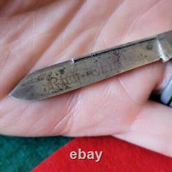 Vieux couteau de poche richement orné de perles de style ancien, vintage et antique avec une lame en forme de chien.